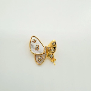 Macro detail of butterfly jewelry pendant with gold plating, mother of pearl and zircon
