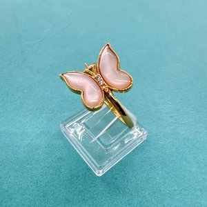 Detailed close-up of a butterfly ring featuring pink wings and crystals on a gold base