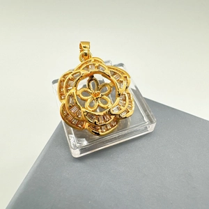 Macro detail of gold flower pendant with layered petals and micro-inlaid crystals