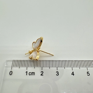 Macro detail of a 1.5cm gold-plated butterfly stud earring with white shell inlay