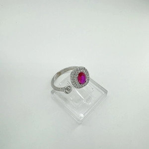 Detailed macro view of adjustable silver ring with oval ruby gemstone and halo zircon setting