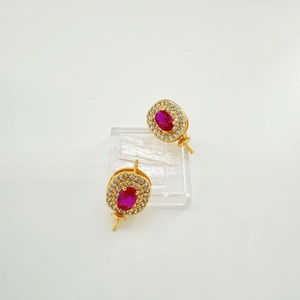Detail of gold oval earrings featuring red zirconia center stones and white halo settings
