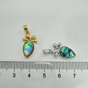 Macro shot of 18K gold and silver plated carrot pendants with shell inlay and cubic zirconia