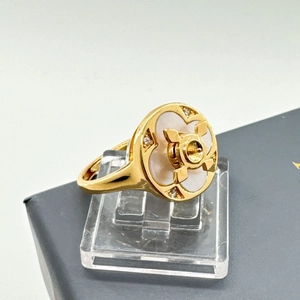 Macro detail of rotating gold flower ring with mother of pearl and zircon stones