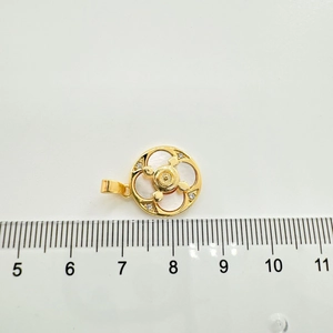 Macro shot of 925 silver gold-plated steering wheel pendant with mother of pearl and gems