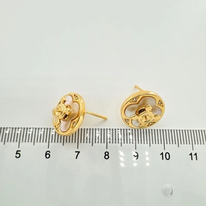 Detail of 1.4cm clover ear studs with pearl inlay and gold finish and center logo
