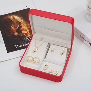 Floral jewelry set with gold metal and white petals in a luxury red gift box