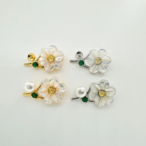 Macro detail of S925 silver flower settings with shell petals and pearl accents