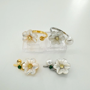 Detail of floral S925 silver pearl ring settings with shell petals and yellow crystals