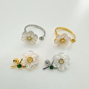 Macro view of S925 silver flower ring with mother of pearl petals and yellow gemstone