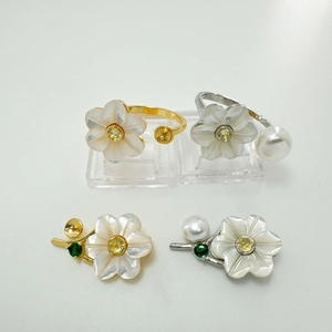 Macro shot of s925 silver flower rings with mother of pearl petals and zircon details