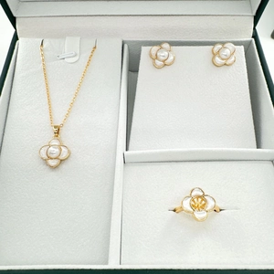 Detail shot of 18K gold plated four-leaf clover jewelry set with mother of pearl in box