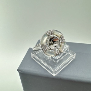 Macro shot of silver ring setting with mother of pearl shell and cubic zirconia stones