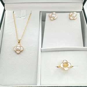 Detailed close-up of a gold-plated four-leaf clover jewelry set featuring mother-of-pearl