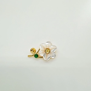 Detailed view of S925 shell flower pin with yellow gemstone and gold leaf accents