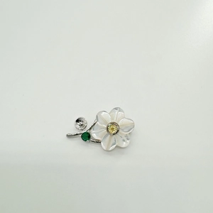 Detail of S925 silver flower setting with white pearlescent petals and yellow zircon