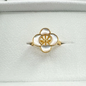 Gold four-leaf clover ring with white mother of pearl inlay and beaded edges in jewelry box