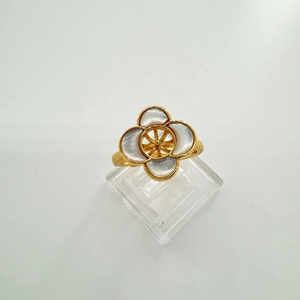 Detailed close-up of a gold-plated four-leaf clover ring with iridescent shell petals
