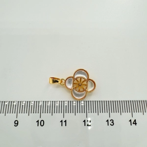 Detail of four-leaf clover pendant with mother of pearl inlay and measurement scale