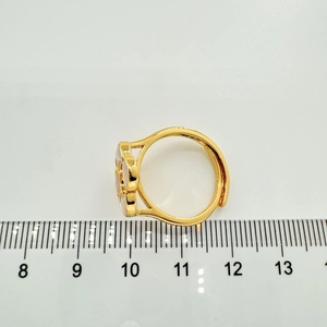 Size measurement of a gold clover ring with shell inlay on a white ruler