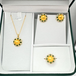 Set gioielli fiore dorato con perle dorate e pietre preziose verdi nel cofanetto