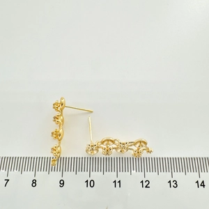 Detailed view of gold flower earrings with 2.5cm ruler scale measurements