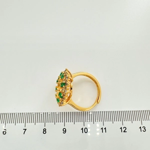 Dettaglio anello regolabile a girasole placcato oro con pietre verdi e scala di misura