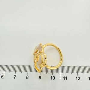 Vista dettagliata di un anello a camelia dorata con madreperla e righello graduato