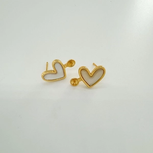 Dettaglio di orecchini a cuore dorati 18k con intarsio in conchiglia e base DIY
