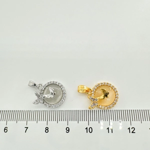 Détail macro de pendentifs papillon en or 18 carats avec règle pour référence de taille
