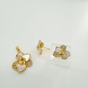 Detailed set of gold plated floral pendant and earrings with zircon and shell inlay