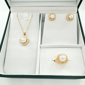 Detail of square zircon halo around white pearls in a green luxury jewelry box