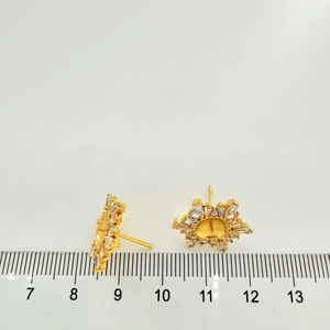 Dettaglio di orecchini a lobo dorati a forma di fiocco di neve con zirconi da 1,5 cm
