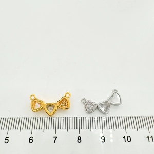 Détail de breloques cœur en or 18K et argent avec zircon et incrustation nacre