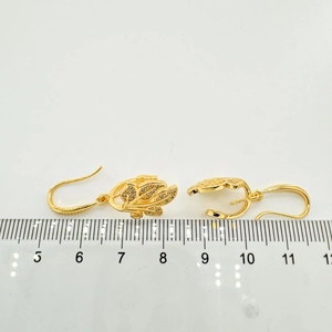 Vue détaillée des boucles d'oreilles fleuries plaquées or 18K avec cristaux et règle de mesure