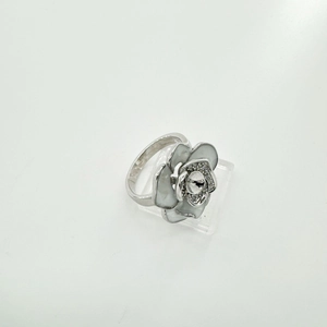 Detailopname van cameliabloem ring met ivoren bloembladen en parelzetting op witte steun