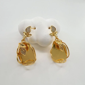 Dettaglio orecchini a foglia placcati oro 18K con cristalli e pendenti con finitura a martello