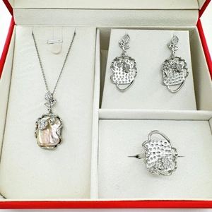 Dettaglio del set di gioielli barocchi con perle irregolari e foglie d'argento in scatola