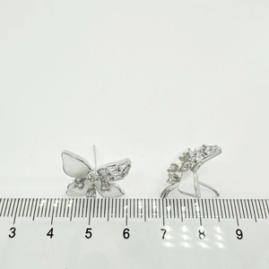 Macro detail of silver butterfly earrings with zircons and shell texture measuring 1.5cm