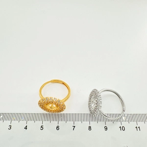 Detailed view of gold and silver sunflower ring settings with a ruler for size reference