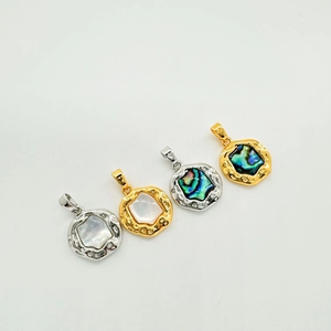 Detail of 18K gold plated oval abalone and white shell pendants with irregular edges