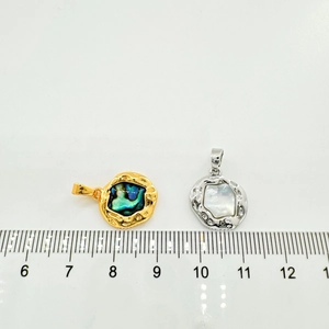 Macro detail of 13mm oval abalone and mother of pearl pendants with hammered metal texture