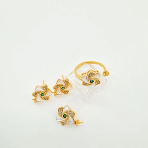 Detalle de set de joyería floral bañada en oro 18K con gema verde y microcristales finos