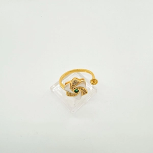 Detalle de anillo de flor ajustable bañado en oro de 18K con piedra verde y pétalos
