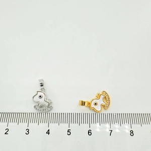 Macro shot of 18K gold and silver rocking horse pendants with shell inlay and size scale