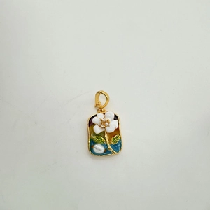 Detailed macro of 18K gold floral enamel pendant with a pearl and vintage finish