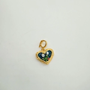 Detail of 18K gold heart pendant with blue enamel, floral patterns and natural pearls