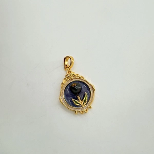 Detailed view of vintage 18K gold-plated enamel pendant with pearl and embossed patterns