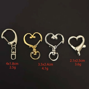Dettaglio macro di chiusure a moschettone e ganci a cuore in metallo oro e argento