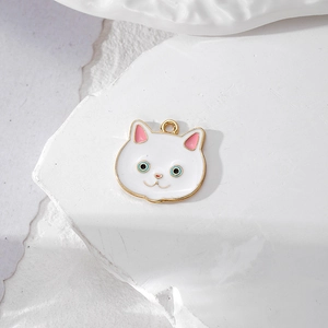 Detail eines weißen Emaille-Kätzchen-Anhängers mit Goldrand und blauen Augen für DIY-Schmuck